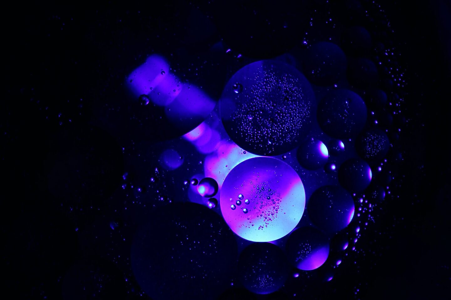 abstract image. purple bubbles glinting in the darkness